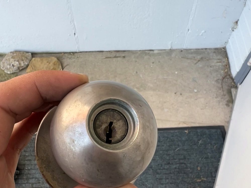 Close-up of a residential knob lock being inspected by a locksmith